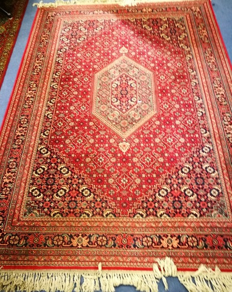 A Persian red ground rug 235cm x 170cm